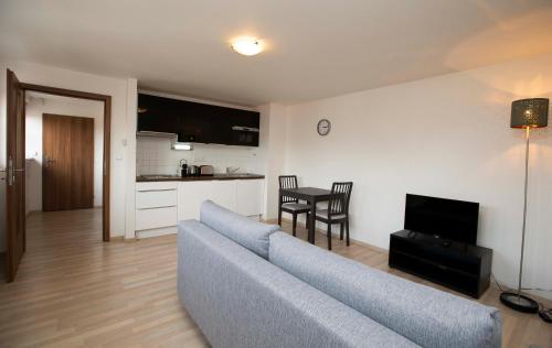 a living room with a blue couch and a kitchen at Greg Apartments Kampa Prague in Prague
