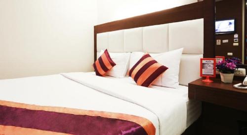 a bedroom with a large white bed with pillows at Studio Nana by iCheck inn in Bangkok