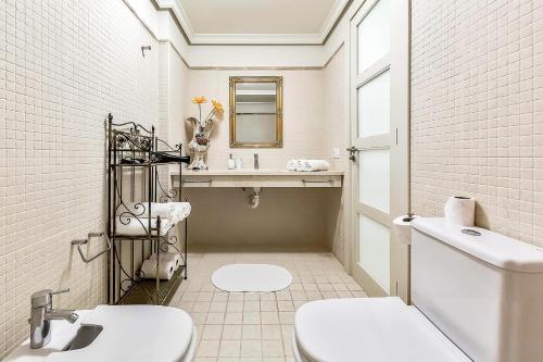 a bathroom with a toilet and a sink and a mirror at 2BED Ocean Apartment in Los Gigantes in Puerto de Santiago