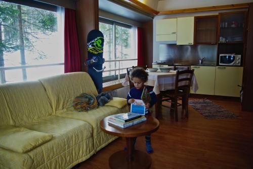 a little boy sitting on a couch with a table at TH 1400 Hotel in Marilleva