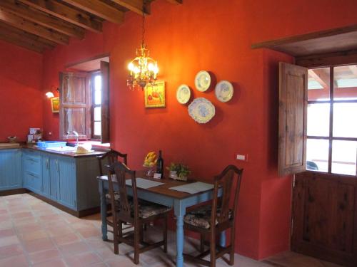 a kitchen with an orange wall with a table and chairs at Haciendas del Valle - Las Kentias in Valle de Guerra