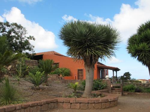 an orange house with palm trees in front of it at Haciendas del Valle - Las Kentias in Valle de Guerra