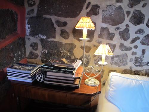 a table with a lamp and a stack of books at Haciendas del Valle - Las Kentias in Valle de Guerra