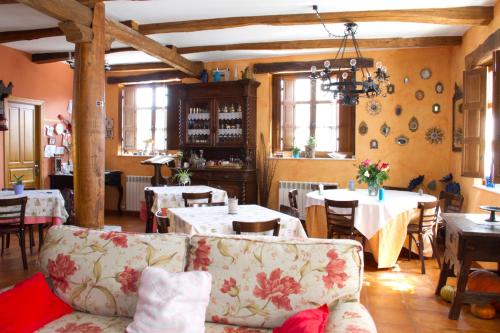 un soggiorno con tavoli, sedie e divano di Hotel Rural La Veleta a Murias de Rechivaldo