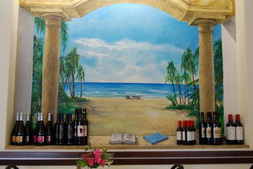 a painting of the ocean with wine bottles on a shelf at Hotel Rivamare in Massignano