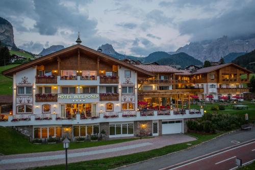 un hôtel avec un grand bâtiment dans les montagnes dans l'établissement Hotel Welponer, à Selva di Val Gardena