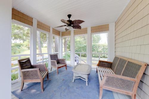 a screened porch with rocking chairs and a ceiling fan at Necessary Escape in York