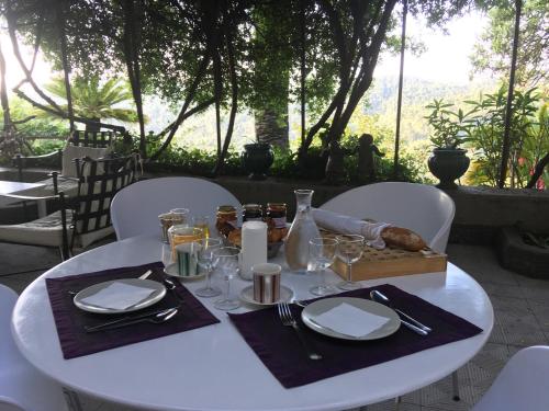 a white table with plates and napkins on it at Les Chapeliers in Claviers