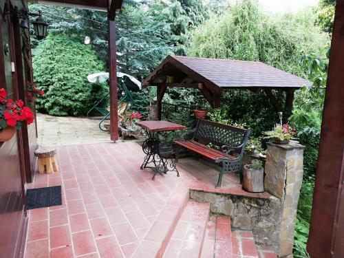 a picnic table and a bench on a patio at Mohás Vendégház Kőszeg Mohás út 107 in Kőszeg