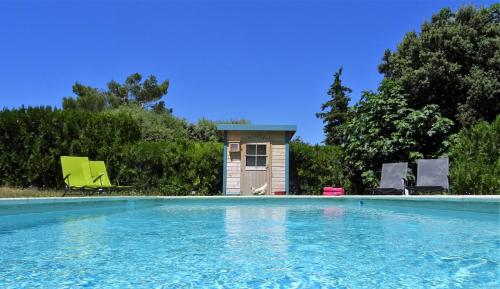 a small house next to a swimming pool at Les Jardins d'Eleusis in Murs