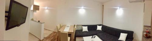 a small living room with a couch and a television at Apartman AS in Bihać