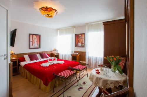 a bedroom with a red bed and a table with chairs at Villa Eeden in Pärnu