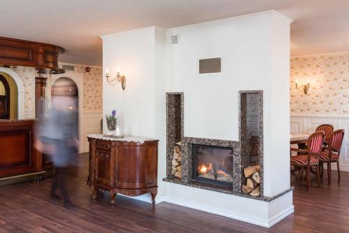 a person walking through a living room with a fireplace at Villa Eeden in Pärnu