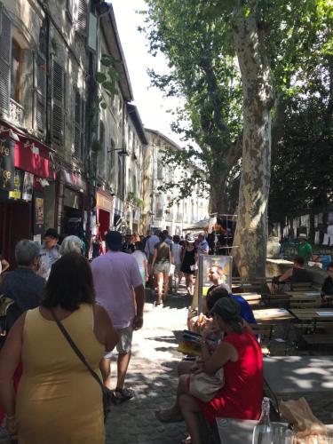 a group of people sitting on a sidewalk in a city at T2 centre ville avec extérieur in Avignon