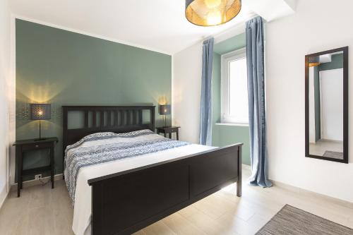 1 dormitorio con 1 cama grande y espejo en Honeymoon Apartment by Quokka 360 - romance by the lake, en Morcote