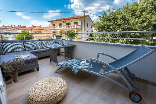 a patio with a chair and a table on a balcony at Lux Apartment Medulin Istria in Medulin