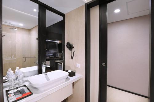 a bathroom with a sink and a mirror at The Alts Hotel in Palembang