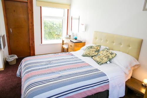 a bedroom with a large bed with a window at The White Heron in Polzeath