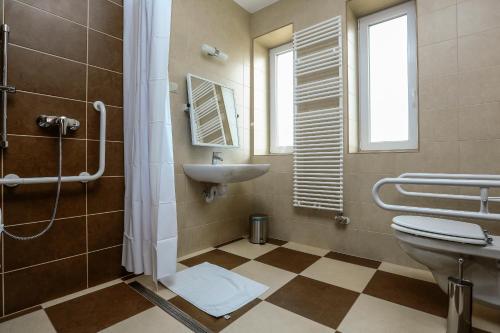 a bathroom with a sink and a toilet and a shower at Gr&aacute;n&aacute;talma Vend&eacute;gh&aacute;z in Feh&eacute;rv&aacute;rcsurg&oacute;