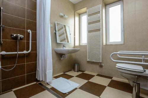 a bathroom with a sink and a toilet and a shower at Gránátalma Vendégház in Fehérvárcsurgó