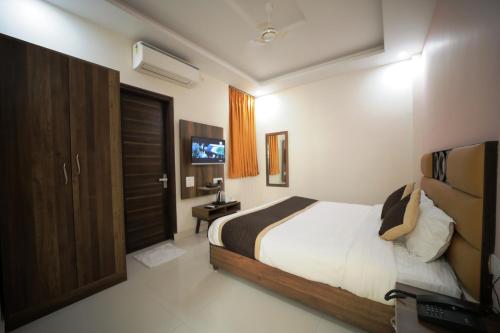 ジャイプールにあるHotel Reeve Innのベッドとテレビのある寝室