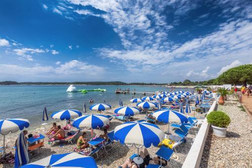 a group of blue and white umbrellas on a beach at Lux Apartment Medulin Istria in Medulin