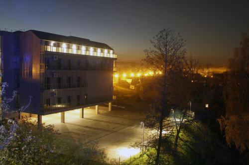a building with lights on in a city at night at Rezidencija "Prieplauka" in Alytus