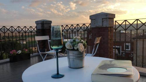 un tavolo con un bicchiere di vino e un libro di Emebed Posada a Castrojeriz
