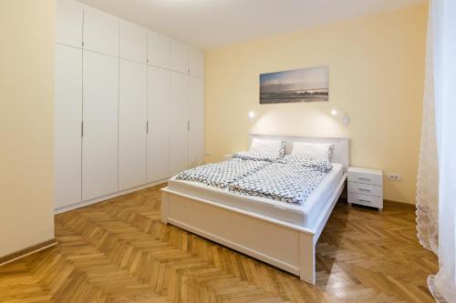 ein weißes Schlafzimmer mit einem Bett und weißen Schränken in der Unterkunft Belgrade Center Apartment IV in Belgrad