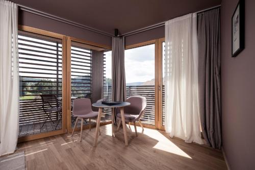 a room with a table and chairs and a large window at Hotel Lamm in Castelrotto