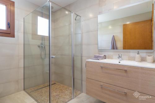 W łazience znajduje się szklana kabina prysznicowa i umywalka. w obiekcie Moli den Sion w mieście Sa Pobla
