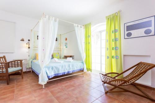 a bedroom with a bed and a chair at Villa Paraiso da Luz by Seewest in Luz
