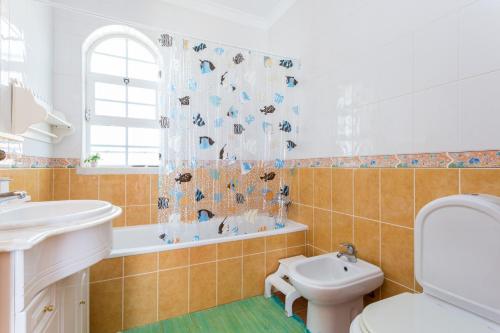 e bagno con lavandino, servizi igienici e vasca. di Villa Paraiso da Luz by Seewest a Luz