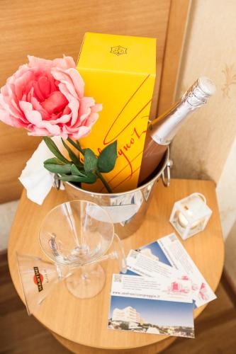 a vase with flowers and a yellow envelope on a table at Hotel San Francisco Spiaggia in Rimini
