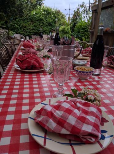ブリニョガン・プラージュにあるHôte Antiqueの赤と白のチェッカー付きテーブルクロス(皿、ワイングラス付)