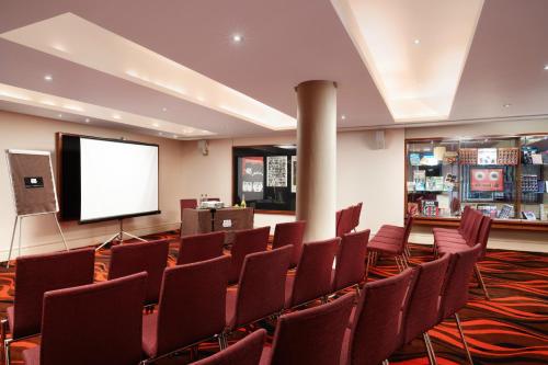 a conference room with chairs and a screen at Hard Days Night Hotel in Liverpool