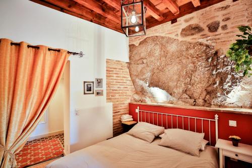 um quarto com uma cama e uma parede de pedra em El Aljibe de San Cipriano em Toledo