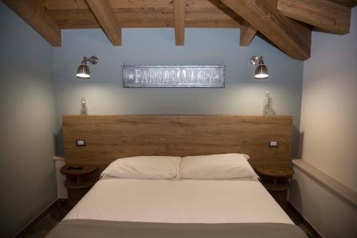 een slaapkamer met een bed met een houten hoofdeinde en verlichting bij La Tenuta di Trimalcione in Pofi