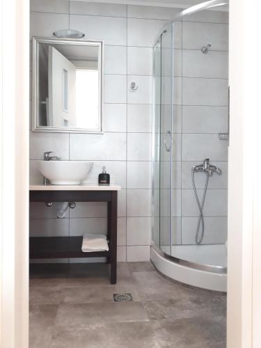 a bathroom with a sink and a shower and a mirror at Minoica Beach Apartments in Amoudara Herakliou