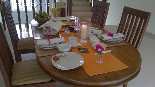 uma mesa de jantar com uma vela, pratos e cadeiras em Villa Jayananda em Dickwella