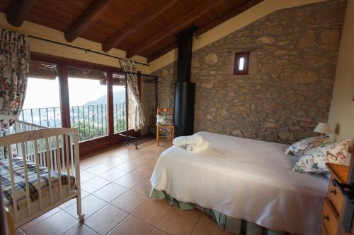 a bedroom with a bed and a stone wall at Les Cases De Borrells in Lladurs