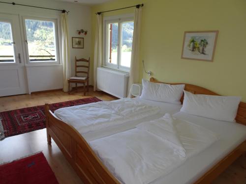 a bedroom with a large bed with white sheets at Ferienhaus in der Sonne in Bad Hindelang