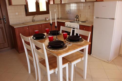 シビリにあるLa casa allegra in rossoのキッチン(テーブル、椅子4脚、白い冷蔵庫付)