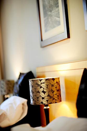 a lamp sitting next to a bed in a room at Villa Paradiso in Hartbeespoort