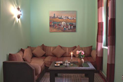 a living room with a brown couch and a table at Riad Maison Du Sud in Essaouira