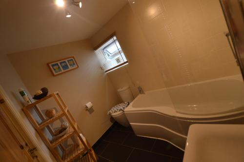 a bathroom with a white toilet and a window at Fox Barn in Staveley