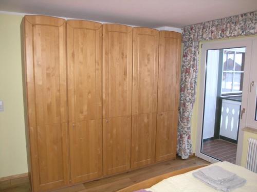 a large wooden cabinet in a room with a window at Pension Edelweiss Top21 in Gosau