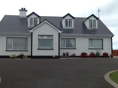 a white house with windows and a driveway at Joe and Aggies in Kilclooney