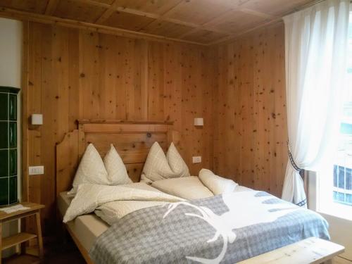 a bedroom with a bed with a wooden wall at Casa Zebrusius - Bepi&Piera's Suite in Valfurva