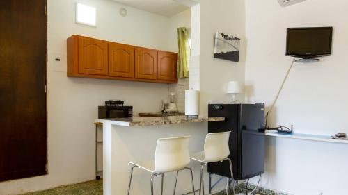 a kitchen with two bar stools and a counter top at Calle Hollanda 1 Bedroom Home in San Juan